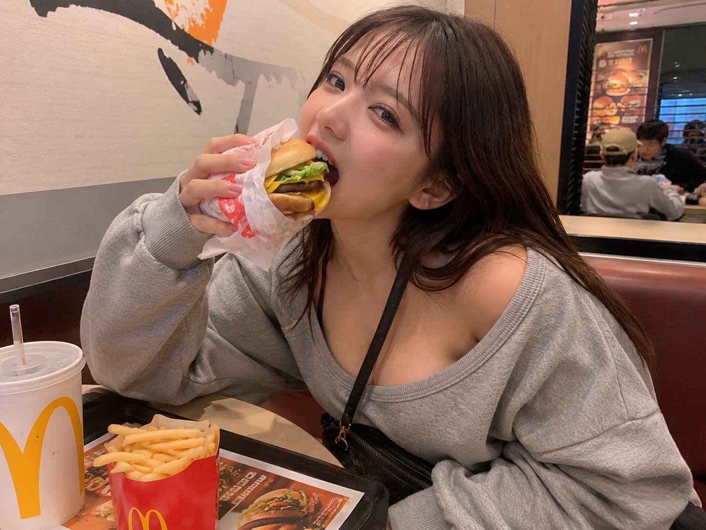 2장 헤더 — 맥도날드에서 햄버거를 한입 베어 무는 일상 셀카. “내 폰에도 있을 법한 사진"의 전형